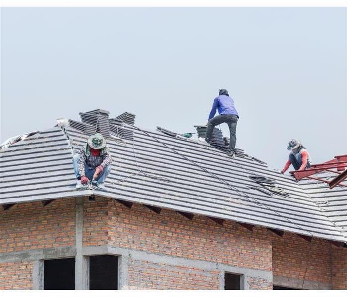 Workers are tiling new roof tiles.